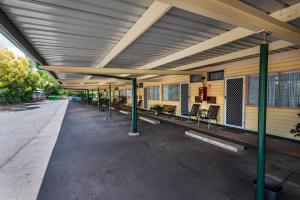 an empty building with tables and chairs under awning at Roma Motel in Roma