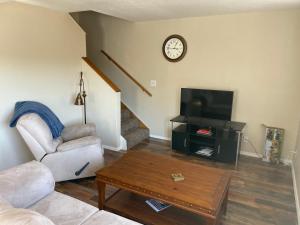 ein Wohnzimmer mit einem Sofa, einem TV und einem Tisch in der Unterkunft Lakeshore Fishing Cabin #12 , dock/boat slip/ramp on location in Lake Ozark