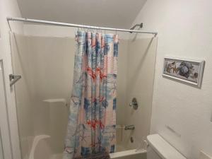 a bathroom with a shower with a shower curtain at Lakeshore Fishing Cabin #12 , dock/boat slip/ramp on location in Lake Ozark