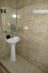 une salle de bain avec un lavabo blanc et une douche dans l'établissement Suite Estudio D1 Alborada Riocentro Norte, à Guayaquil 24 autres photos