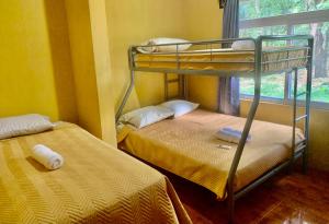 two bunk beds in a room with a window at Casa 3 a 5 min del Irtra in Retalhuleu