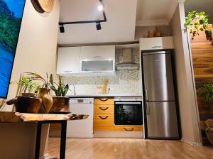 een keuken met een roestvrijstalen koelkast en houten kasten bij The Luxury of Life With a Feeling of Nature in Esenyurt