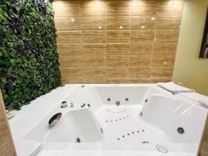 a white bath tub with a sink in a bathroom at Apartmani SLEEP&JOY in Zlatibor
