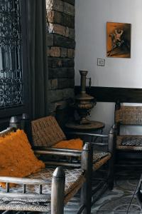 a room with two chairs and a table with orange blankets at Titrite Ouzoud in Ouzoud