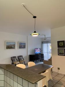 a kitchen and living room with a table and chairs at Apartamento Pé na Areia e águas tranquilas no centro de Guarapari in Guarapari +20 photos