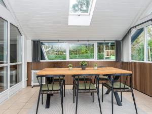 un patio con mesa de madera y sillas en 6 person holiday home in Hovborg, en Hovborg