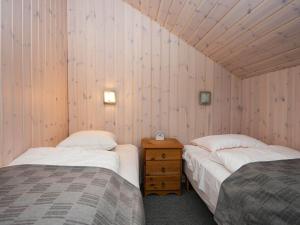 Holiday home Ansager XLIII في Ansager: سريرين في غرفة بجدران خشبية