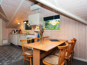 a kitchen and dining room with a wooden table and chairs at Holiday home Ansager XLIII in Ansager