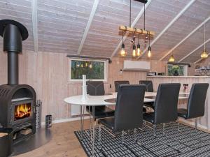 een kamer met een tafel en een houtkachel bij Holiday home Ansager XLI in Ansager