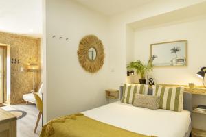 a white bedroom with a bed and a mirror at Seixal Bay Apartments in Arrentela