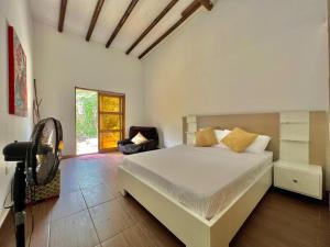 - une chambre avec un grand lit blanc et une chaise dans l'établissement Medusa Hostel Isla Tintipan, à Tintipan Island