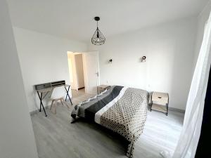 a white bedroom with a bed and a desk at 178A - T3 Tout Confort du Gond - 70 m2 in Le Gond-Pontouvre