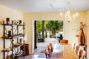 un comedor con una gran mesa de madera y sillas en Cloverdale Creekside Retreat, en Cloverdale