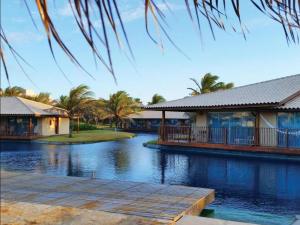 une maison avec un quai à côté d'une masse d'eau dans l'établissement DOM PEDRO LAGUNA BEACH RESORT & GOLF, à Fortaleza