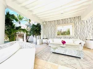 a living room with white furniture and palm trees at Dream Luxury B&b Watamu in Watamu