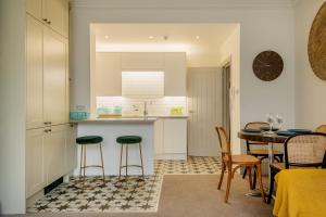 a kitchen and dining room with a table and chairs at Beautiful, central, 3 min walk from beach, 2 King doubles in Brighton & Hove