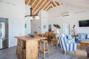 kuchnia i salon ze stołem i krzesłami w obiekcie Sunset Cove w mieście Forbes Hill