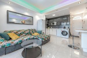 ein Wohnzimmer mit einem Sofa und einer Küche in der Unterkunft Beautiful deluxe apartment Sun and Sea in Adeje