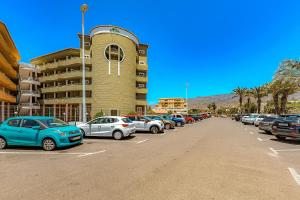 a parking lot with cars parked in front of a building at Beautiful deluxe apartment Sun and Sea in Adeje