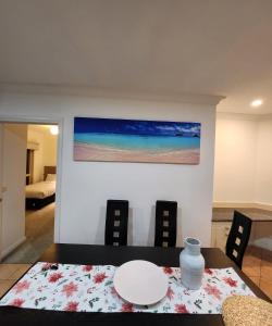 uma sala de jantar com uma mesa e um quadro na parede em Daisy Villa em Warrnambool