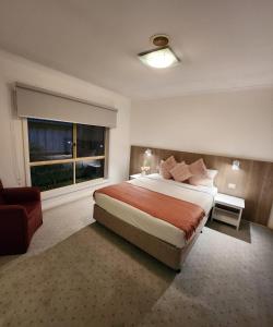 Un dormitorio con una cama grande y una ventana en Daisy Villa, en Warrnambool