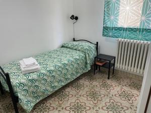 1 dormitorio con 1 cama con colcha verde y blanca en Il Balcone sui Sicani APARTMENT, en Cammarata