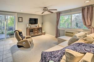 a living room with a couch and a tv at Cozy Dix Hills Apt with Deck about 7 Mi to Beach! in Dix Hills