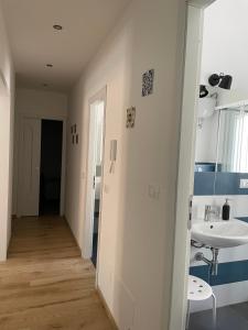 a white bathroom with a sink and a mirror at Il Balcone sui Sicani APARTMENT in Cammarata