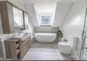 ein Badezimmer mit einer Badewanne, einem WC und einem Waschbecken in der Unterkunft Halekulani Devon Homestay in Torquay