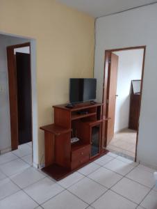 een woonkamer met een tv op een houten entertainmentcentrum bij Casa da Pirâmide in São Thomé das Letras