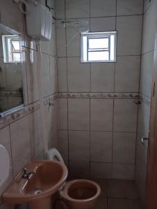 een badkamer met een wastafel, een toilet en een raam bij Casa da Pirâmide in São Thomé das Letras