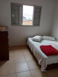 Un dormitorio con una cama con una manta roja. en Casa da Pirâmide, en São Thomé das Letras