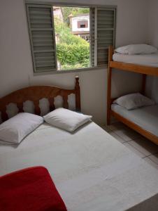 a bedroom with two bunk beds and a window at Casa da Pirâmide in São Thomé das Letras