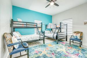 a bedroom with two bunk beds and two chairs at Sea Crest in Galveston