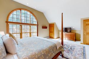 1 dormitorio con cama y ventana grande en Casita Bacon, en Vermont Ventures