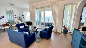 un soggiorno con tavolo e sedie blu di Casa Alba Serena By The Sea a Marzamemi