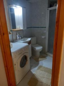 a bathroom with a washing machine and a toilet at EKONOMİ ÜNİVERSİTESİNE 5 Dk. 2+1 EŞYALI DAİRE in Balcova