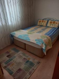 a bedroom with a bed and a rug on the floor at EKONOMİ ÜNİVERSİTESİNE 5 Dk. 2+1 EŞYALI DAİRE in Balcova