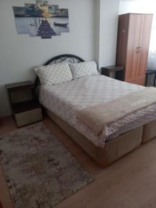 a bedroom with a large bed and a rug at EKONOMİ ÜNİVERSİTESİNE 5 Dk. 2+1 EŞYALI DAİRE in Balcova