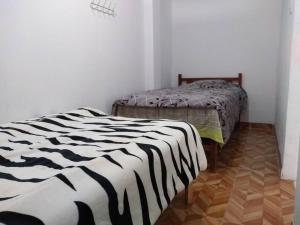 two beds in a room with white walls at Departamento-Natural M4 in Chiclayo