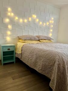 a bedroom with a bed with lights on it at Moderno Departamento con Estacionamiento Privado en Los Ángeles in Los Ángeles