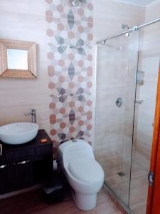 a bathroom with a toilet and a sink and a shower at Hotel Med Suites 94 in Barranquilla