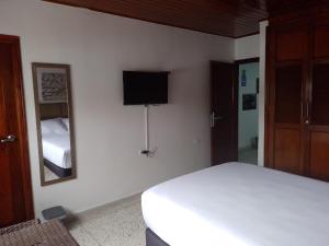 a bedroom with a white bed and a mirror at Hotel Med Suites 94 in Barranquilla