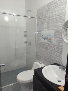 a bathroom with a shower and a toilet and a sink at Hotel Med Suites 94 in Barranquilla