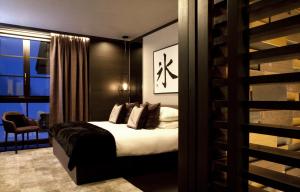 a bedroom with a bed with pillows and a window at Kasara Niseko Village Townhouse - Small Luxury Hotels of The World in Niseko