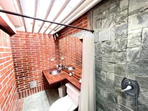 a bathroom with a sink and a brick wall at Casa 38 de la Parcelación Lagos de Pontezuela in El Retiro