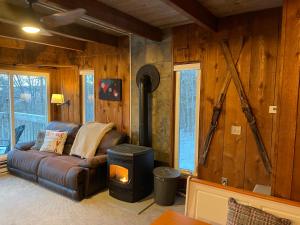 a living room with a leather couch and a wood wall at Mandy's Mountain Chalet in Dover