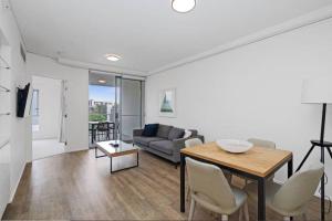 a living room with a table and a couch at Lovely 2- Bedroom Rental Unit with Free Parking in Brisbane