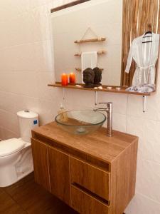 Medusa Hostel Isla Tintipan في Tintipan Island: حمام مع حوض زجاجي ومرحاض