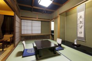 una sala da pranzo con tavolo e sedie in una stanza di Okada Ryokan Warakutei a Takayama